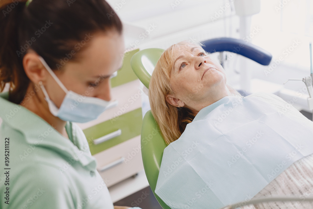 Senior woman having dental treatment at dentist's office. Woman is being treated for teeth Senior woman having dental treatment at dentist's office. Woman is being treated for teeth