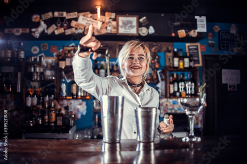 Girl bartender concocts a cocktail at the public house