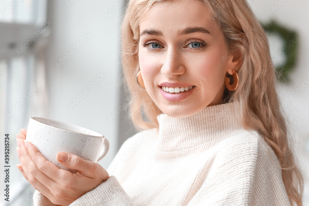 Beautiful young woman in warm clothes drinking tea at home Beautiful young woman in warm clothes drinking tea at home