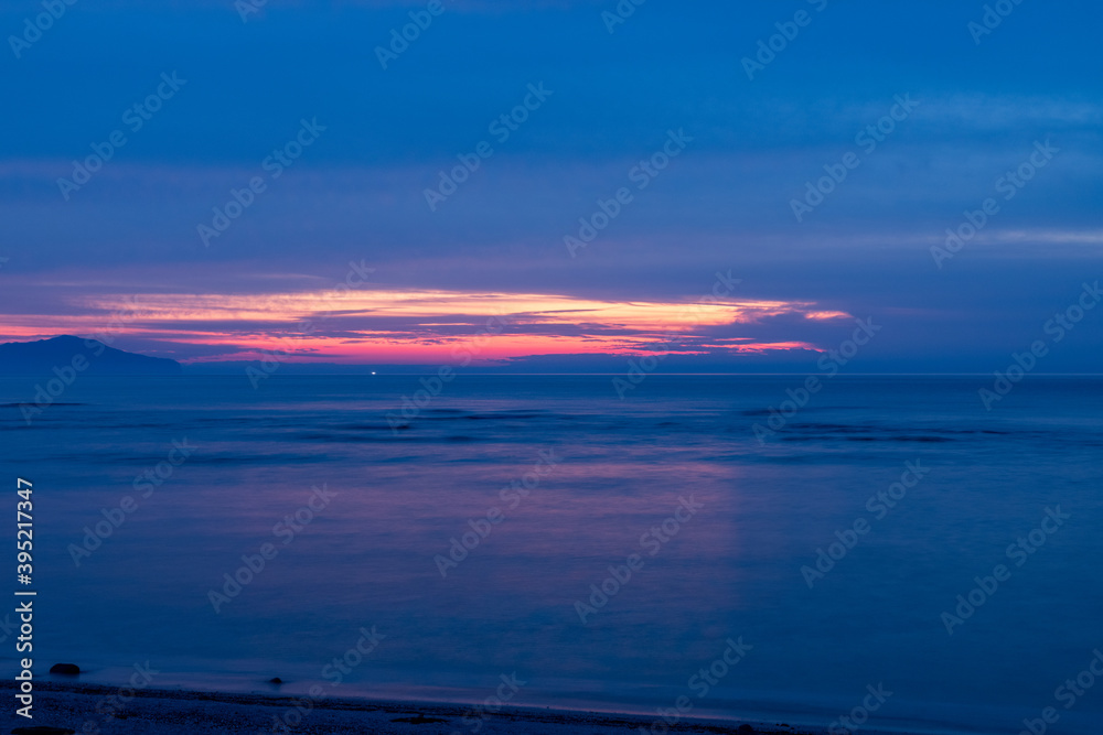 海岸から見る夕陽と水平線