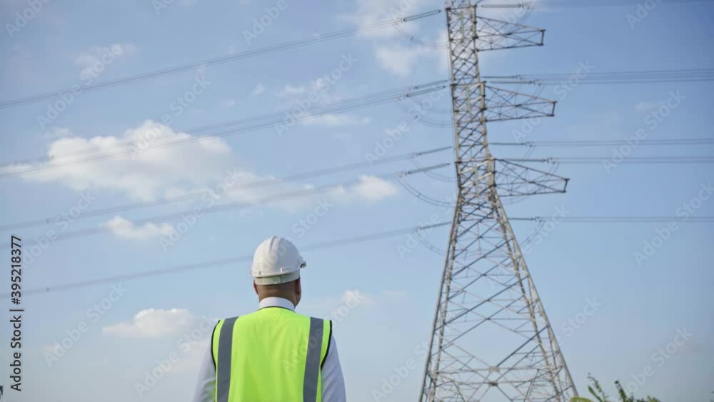 Electrical engineer working and look forward. He walking on the High voltage pole and blue sky background.4K Resolution.
Electrical engineer working and look forward. He walking on the High voltage pole and blue sky background.4K Resolution.