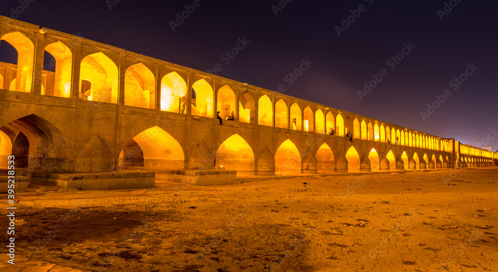 Arches of night view with light effect of Allahverdi Khan Bridge, also named  Si-o-seh pol bridge across the Zayanderud river in Isfahan, Iran, a famous historic building in Persian History