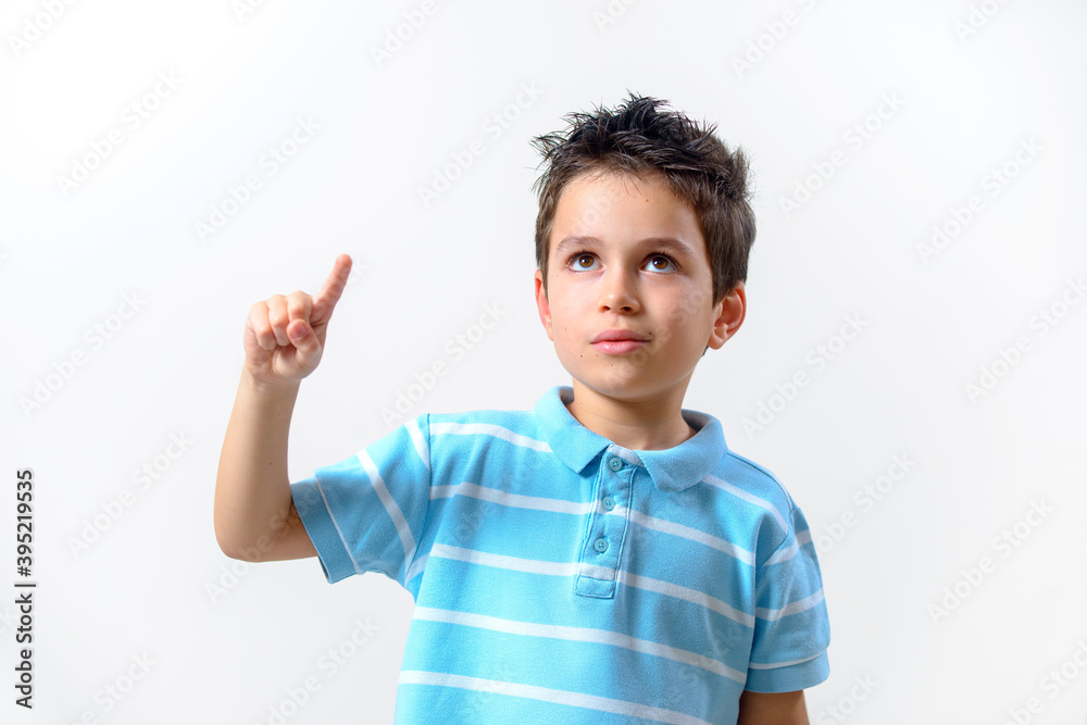 A boy in a blue T-shirt with a brooding face raised his finger up. A boy in a blue T-shirt with a brooding face raised his finger up.