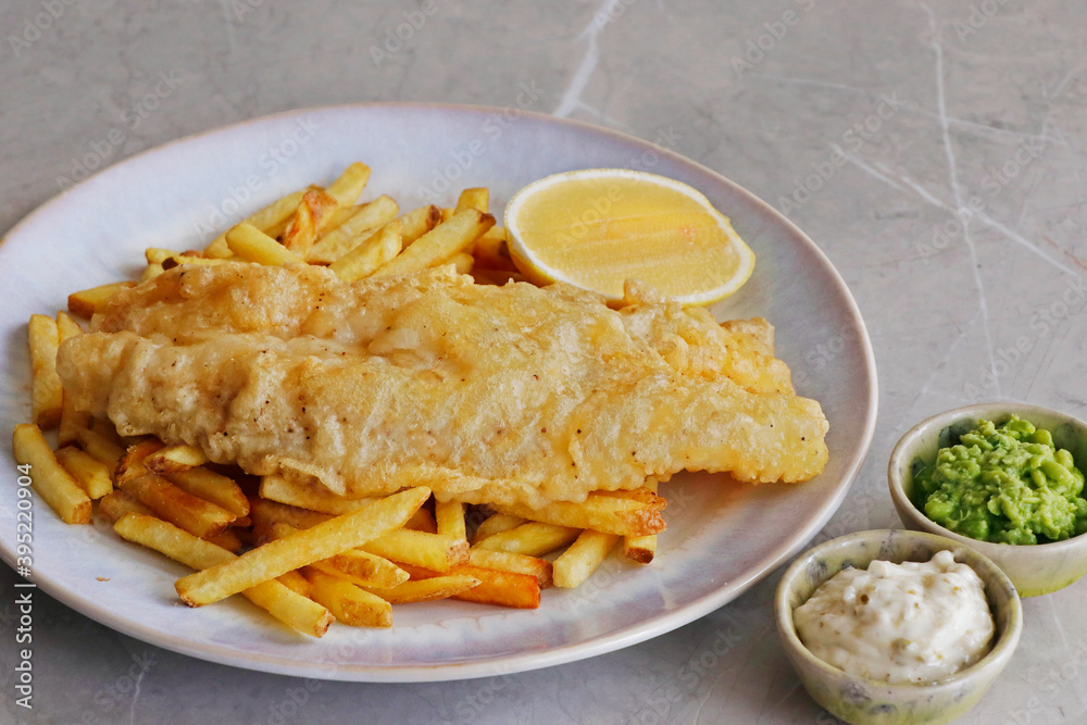 fish and chips with lemon wedge, mushy peas and tartare sauce fish and chips with lemon wedge, mushy peas and tartare sauce