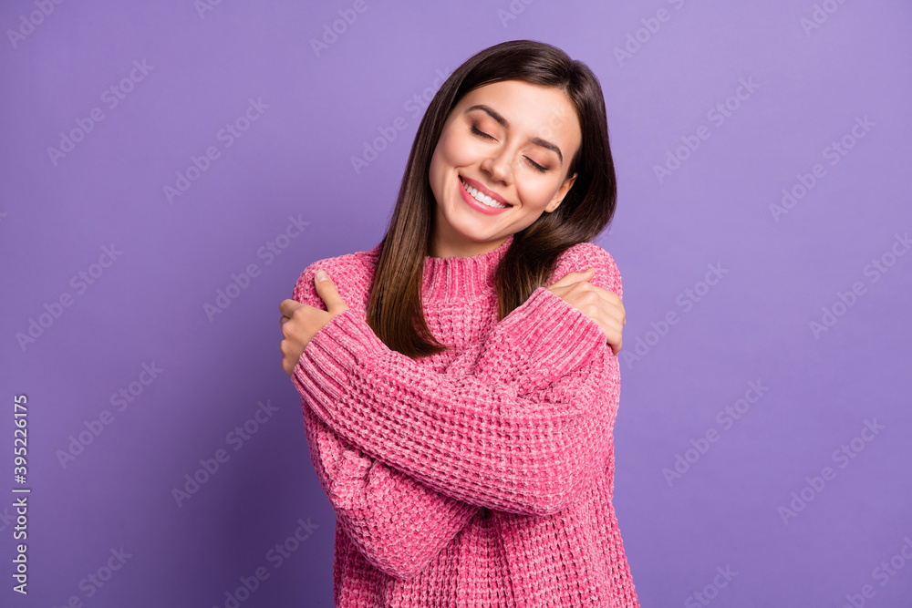 Photo portrait of cute dreamy brunette girl wearing pink pullover closed eyes embracing herself isolated on vibrant violet color background Photo portrait of cute dreamy brunette girl wearing pink pullover closed eyes embracing herself isolated on vibrant violet color background