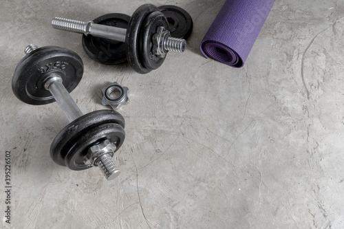 Steel dumbbells on the cement floor in the gym For bodybuilders