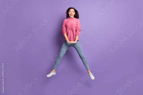 Full length body size photo of jumping girl careless childish laughing isolated on bright violet color background