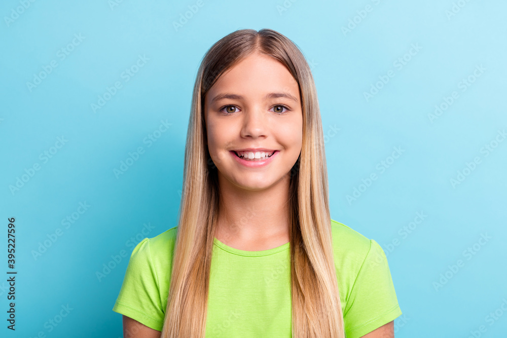 Portrait of young happy smiling cheerful good mood girl wearing green t-shirt look camera isolated on blue color background Portrait of young happy smiling cheerful good mood girl wearing green t-shirt look camera isolated on blue color background