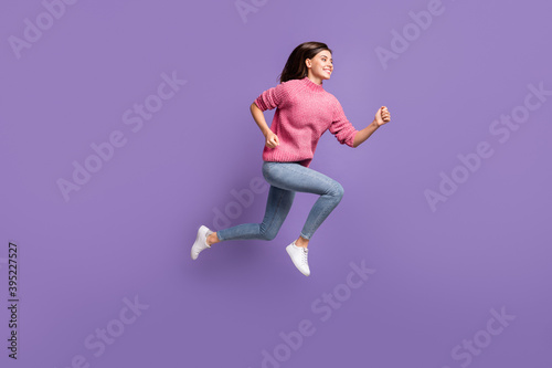Full length profile photo of charming running lady good mood toothy smile isolated on purple color background