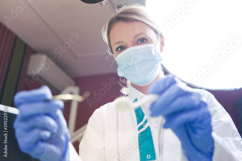 Dentist with instruments doing examination in dental office. Portrait of dentist. Dentist wearing mask and gloves during healthcare check of patient