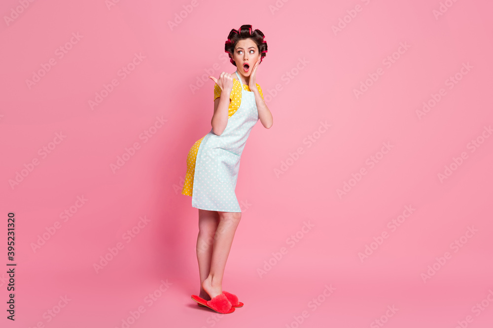 Full length body size profile side view of her she amazed housewife posing demonstrating advert copy space isolated over pink pastel color background Full length body size profile side view of her she amazed housewife posing demonstrating advert copy space isolated over pink pastel color background