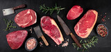 Meat panorama. Various beef steaks, a flat lay top shot on a black background with knives and seasoning