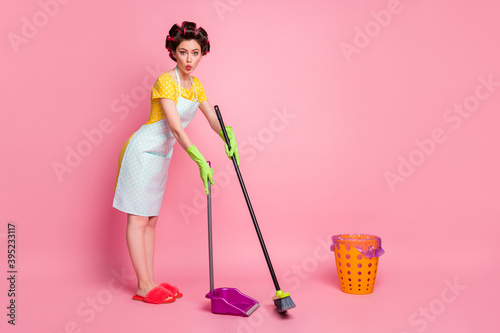 Full length body size view of nice amazed coquetish funky homemaker cleansing dust dustpan pout lips isolated on pink pastel color background photo