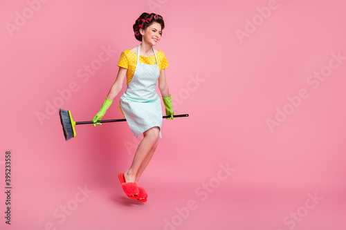 Full length body size view of attractive cheerful maid sitting besom having fun flying isolated on pink pastel color background