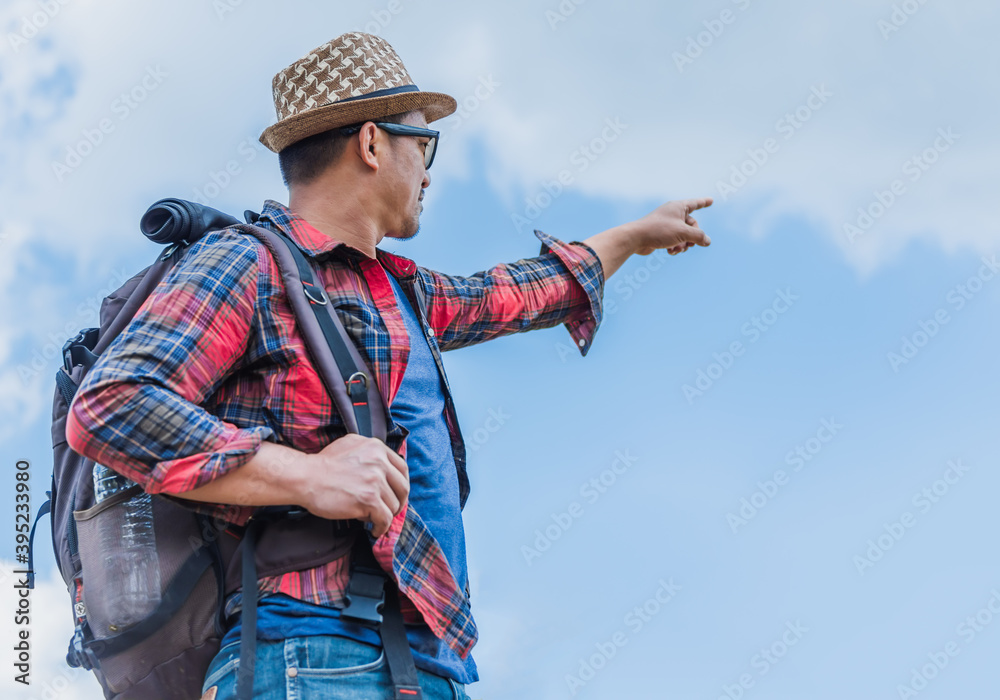 A young man traveler with backpack walking travel in the forest .lift to the sky. A young man traveler with backpack walking travel in the forest .lift to the sky.