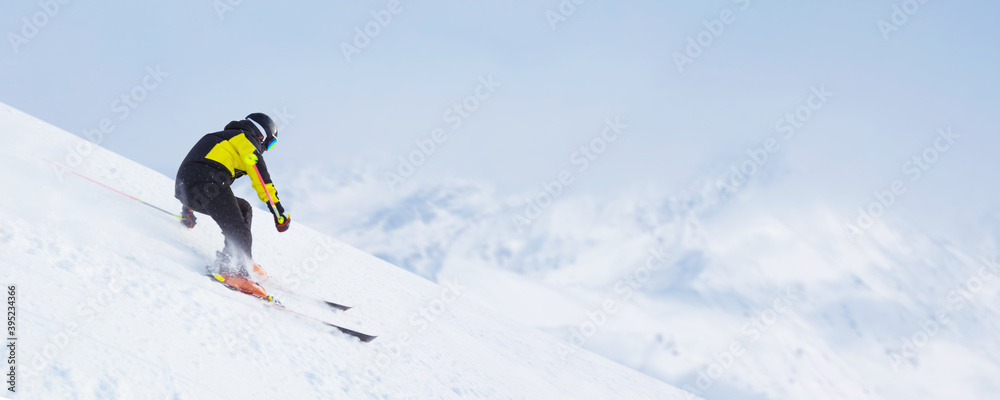 Skier skiing downhill in mountains