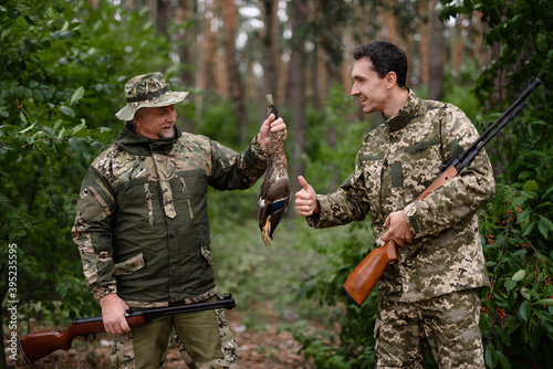 Proud Dad and Son in Camouflage Holding Shot Duck.