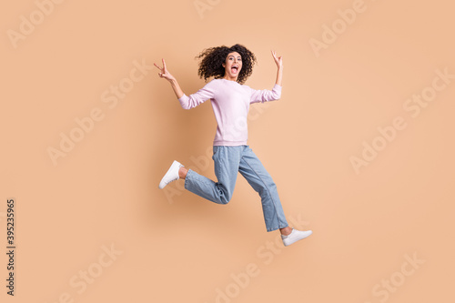 Full body portrait of excited crazy person jump run open mouth show v-sign isolated on brown color background