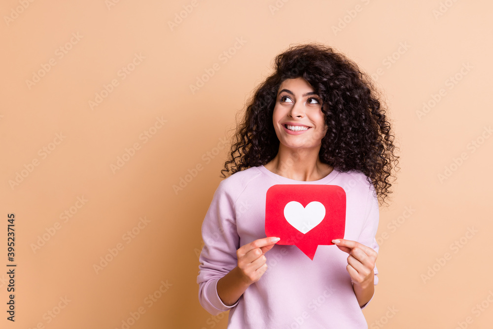 Photo of optimistic curly girl show like look empty space wear sweater jeans isolated on peach color background Photo of optimistic curly girl show like look empty space wear sweater jeans isolated on peach color background