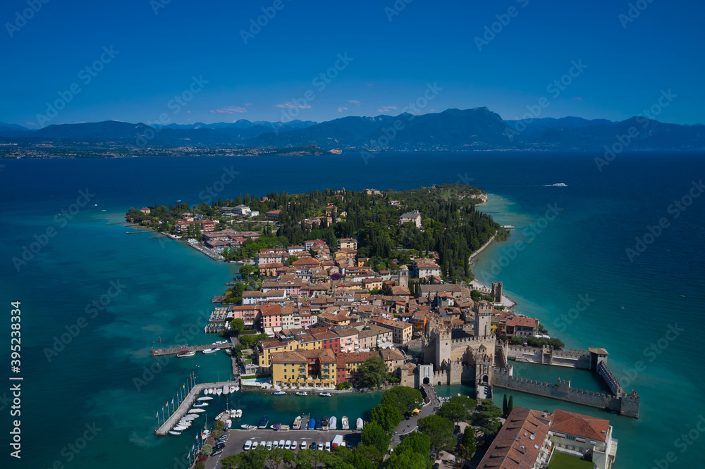 Sirmione, Lake Garda, Italy. Panoramic aerial view of the central city of Sirmione. In the background mountains, blue sky. In the summertime