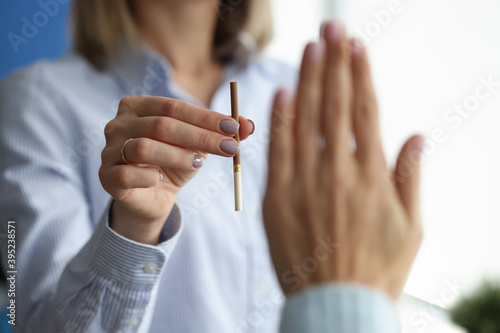 Woman offers cigarette to man who makes negative gesture. The harm of smoking on the human body concept