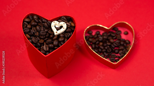 Colorful open box gift present with roasted coffee beans on red background. Concept Valentine's Day. Love symbol, copy empty space for text, heart shape isolated. Brown shiny whole grains  © Volodymyr