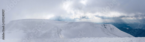Sunset over a snow-covered ridge. Panorama from multiple shots. © Oleksiy