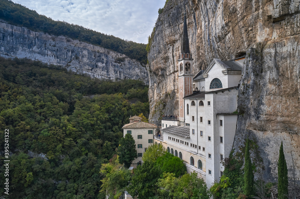 The unique Sanctuary Madonna della Corona church in the rock. Aerial view of the church on the sheer cliff. Italian church at high altitude in the Alps. The sanctuary is high in the mountains of Italy