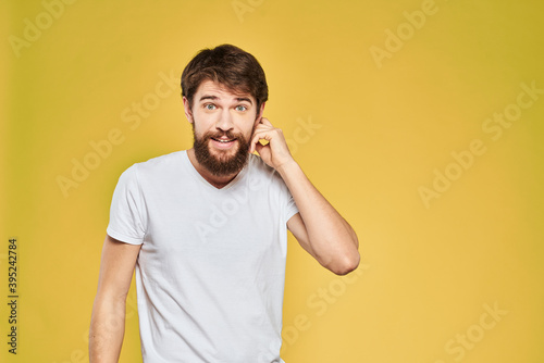 Bearded man in white t-shirt emotions close-up fun yellow background