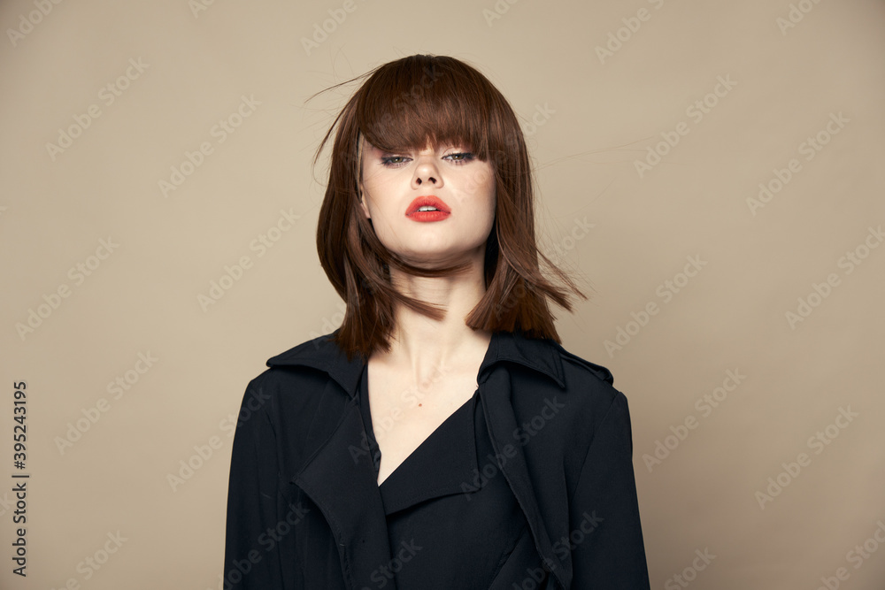 Funny woman black coat smile smiling on a beige background Funny woman black coat smile smiling on a beige background