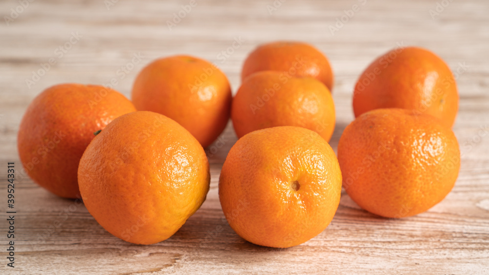 Scattered clementines, tangerines, mandarins, oranges on bright wooden background. Winter vitamin C Scattered clementines, tangerines, mandarins, oranges on bright wooden background. Winter vitamin C