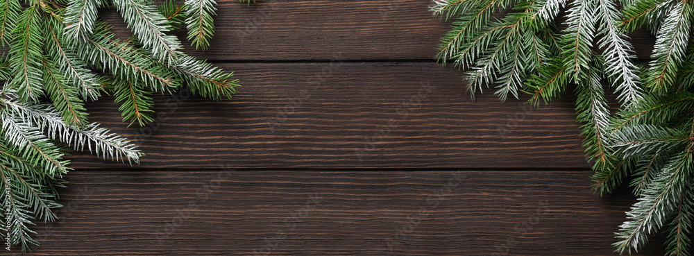 Christmas or New Year background with fir branches on a dark wooden background. Place for your text. Banner. Christmas or New Year background with fir branches on a dark wooden background. Place for your text. Banner.
