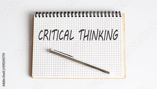 Critical thinking text written on a notebook with pen