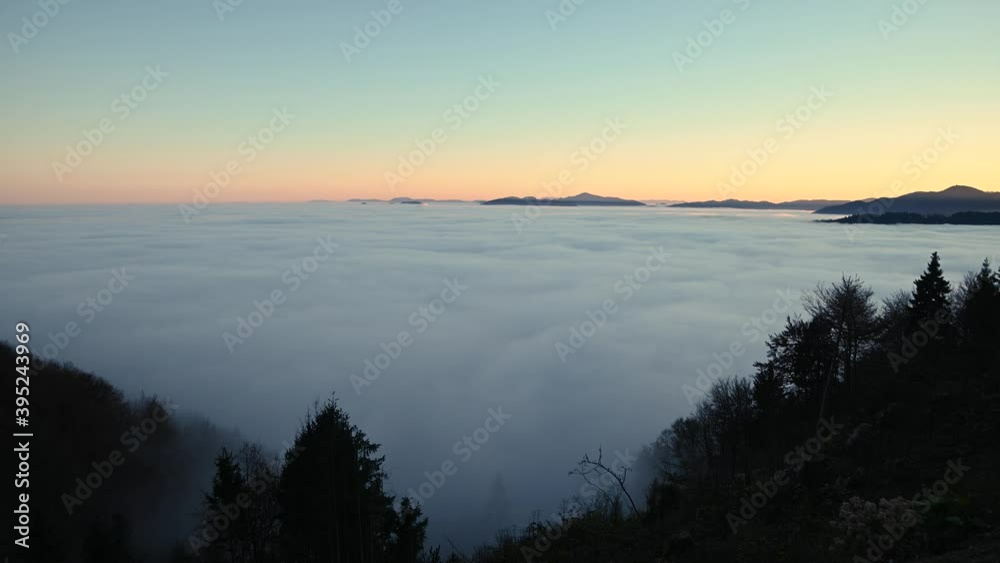 Time lapse elevated view of inversion clouds moving over Ljubljana basin, Slovenia. Colorful sunset with reflection on clouds. Amazing view of natural wonder. Static shot, wide angle Time lapse elevated view of inversion clouds moving over Ljubljana basin, Slovenia. Colorful sunset with reflection on clouds. Amazing view of natural wonder. Static shot, wide angle