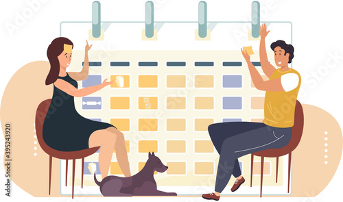 Happy people playing game sitting near big calendar. Man and woman playing the game guess who i am, sitting with notes opposite each other, having fun together. Entertainment and leisure pastime