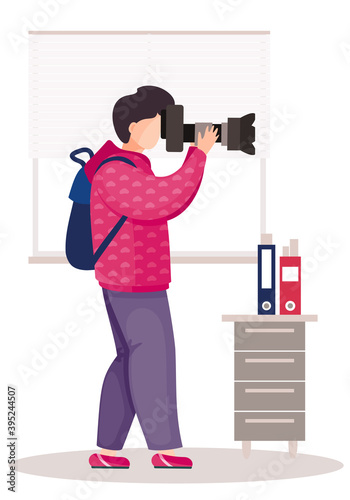 The guy with backpack standing with the camera in his hands. The photographer takes pictures in the office. Photographic art. A man prepares camera for a photo shoot. Working day in the office