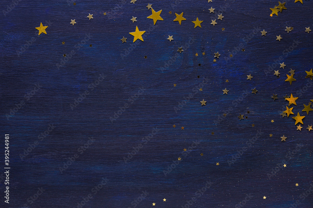 Dark-blue wooden background with golden stars.  Flat lay. - obrazy, fototapety, plakaty 