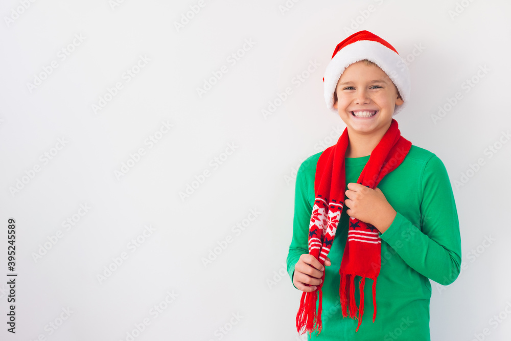 Portrait of happy boy wearing Santa Claus hat and winter scarf. Merry Christmas time. Portrait of happy boy wearing Santa Claus hat and winter scarf. Merry Christmas time.