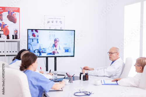 Medical physicians talking with medical specialist during teleconference. Medicine staff using internet during online meeting with expert doctor for expertise.