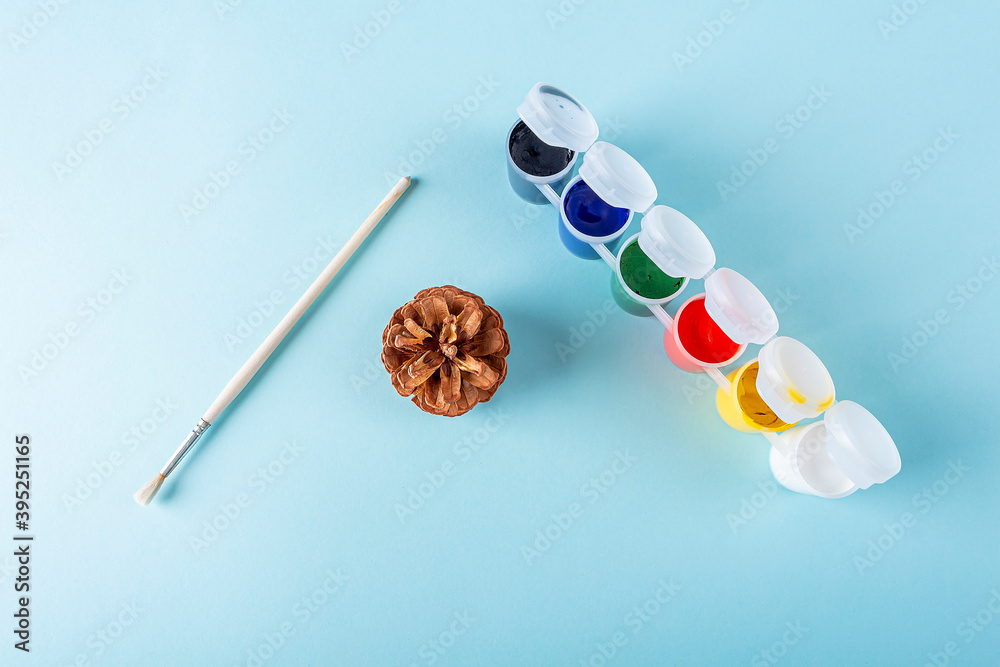 Concept of DIY and kid's creativity. Step by step instruction: painting pine cone. Step 1 tools: cone, brush, paint. Children Christmas and New Year craft