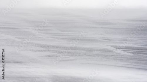 Textured snow surface during wind. Selective focus.
