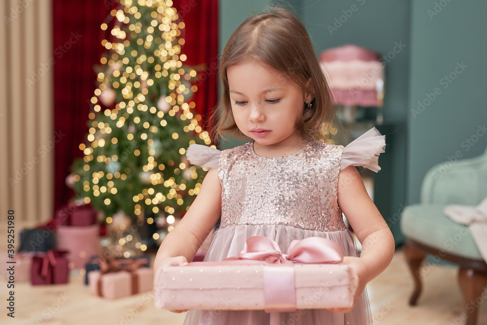 Christmas baby. Child girl with gifts on background of Christmas tree. Xmas greeting card. Merry christmas background. Happy New Year! Winter celebrations, holidays and vacations. Christmas baby. Child girl with gifts on background of Christmas tree. Xmas greeting card. Merry christmas background. Happy New Year! Winter celebrations, holidays and vacations.