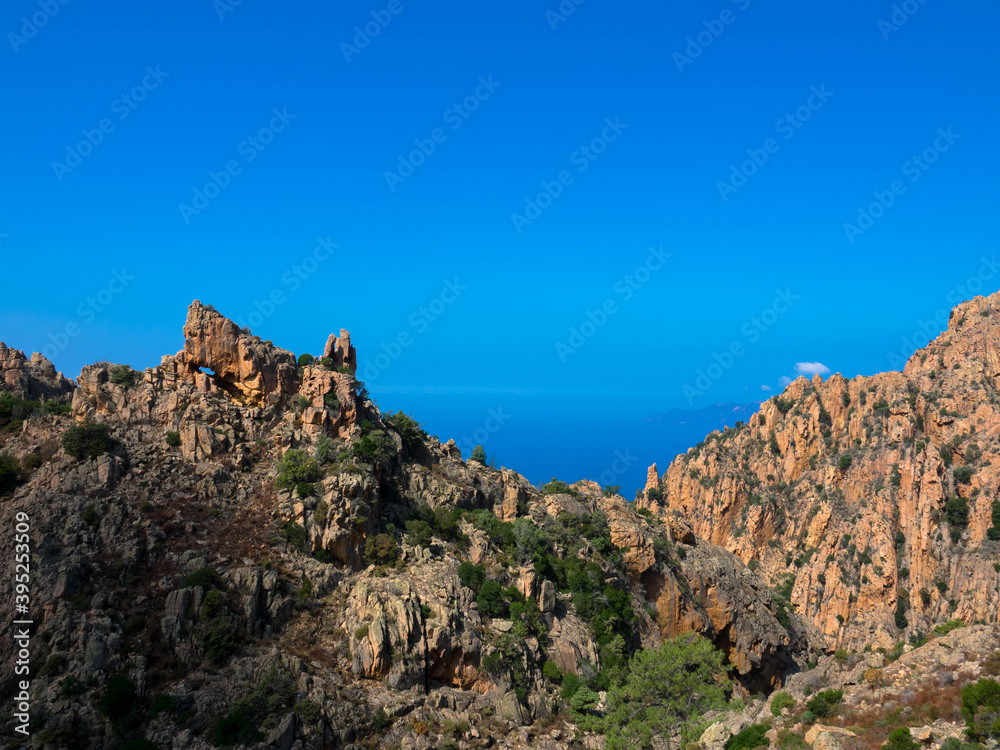 Beautiful view of sunlit red mountains and mediterranean sea in Calanches area on corsica island, near Village Piana Beautiful view of sunlit red mountains and mediterranean sea in Calanches area on corsica island, near Village Piana