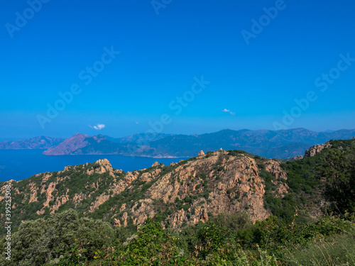 Beautiful view of sunlit red mountains and mediterranean sea in Calanches area on corsica island, near Village Piana