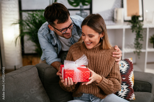 Obraz na plátně Boyfriend surprising his girlfriend with a gift