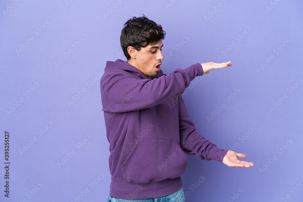 Young cool man shocked and amazed holding a copy space between hands. Young cool man shocked and amazed holding a copy space between hands.