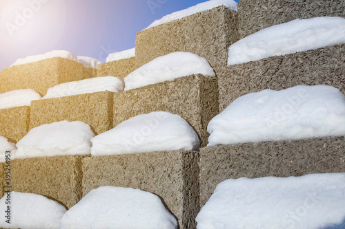 large blocks of arbolite stacked in a stack against a blue sky, foreground and background blurred with bokeh effect photo