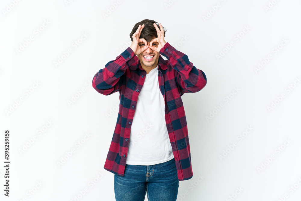Young cool man excited keeping ok gesture on eye. Young cool man excited keeping ok gesture on eye.