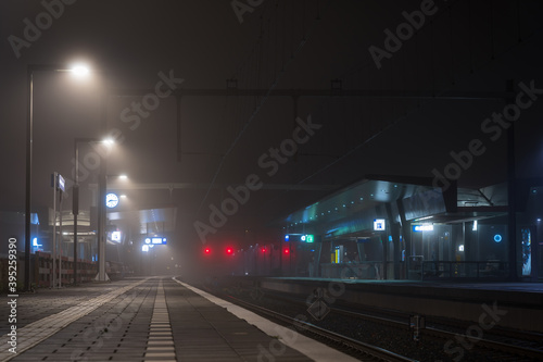 Foggy night at a modern railway platform in a city.