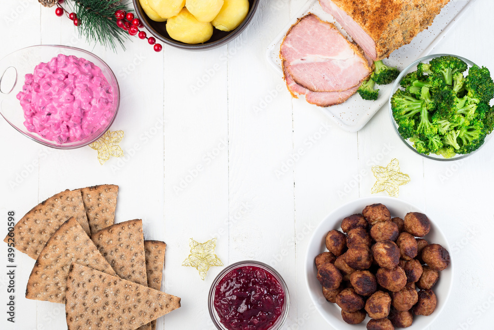 Traditional swedish and scandinavian Christmas table with baked ham in mustard crumble crust, beet salad, whole grane crackers, meatballs with lingonberry jam, horizontal frame, top view, copy space Traditional swedish and scandinavian Christmas table with baked ham in mustard crumble crust, beet salad, whole grane crackers, meatballs with lingonberry jam, horizontal frame, top view, copy space